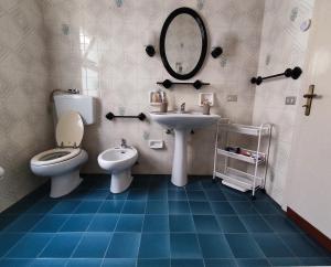 een badkamer met een wastafel, een toilet en een spiegel bij Il Patio in Sampieri