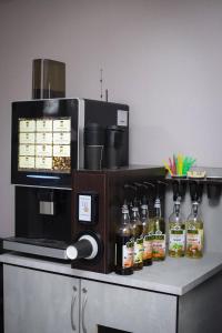 a counter with a coffee maker and bottles of alcohol at Hotel 33 in Almaty