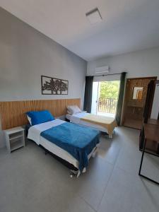 a bedroom with two beds and a window at Residencial Dona Francisca in Florianópolis