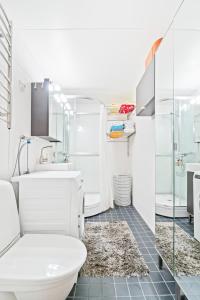 a white bathroom with a toilet and a sink at 2 room apartment in Pasila in Helsinki