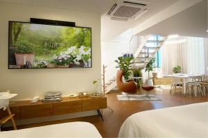 uma sala de estar com uma televisão pendurada na parede em Garden Pool Villa Lee Chung Jung em Seul