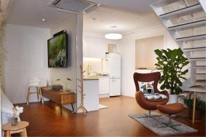 a living room with a chair and a kitchen at Garden Pool Villa Lee Chung Jung in Seoul