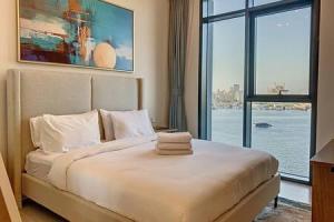 a bedroom with a large bed with a large window at Key View - Creek Edge T2 in Dubai