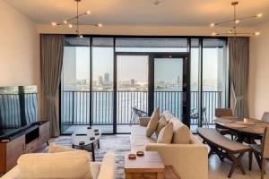 a living room with a couch and a large window at Key View - Creek Edge T2 in Dubai