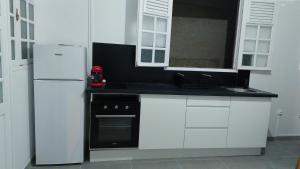 uma cozinha com armários brancos e um frigorífico branco em Lafleur_doré Studio em Le Vauclin