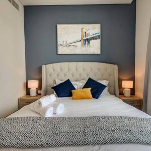 杜拜的住宿－Beachwalk Luxury 2BR with Infinity Pool and Views，一间卧室配有一张带蓝色墙壁的大床