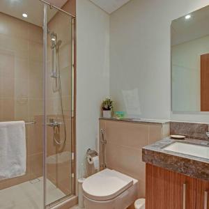 a bathroom with a shower and a toilet and a sink at Beachwalk Luxury 2BR with Infinity Pool and Views in Dubai