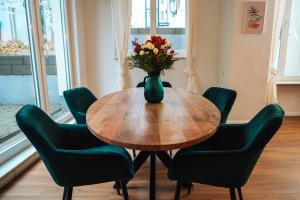 un vaso di fiori su un tavolo di legno con sedie di Global Living - Design Apartment I Central I Beamer I Kitchen I Terrace I Berlin a Berlino
