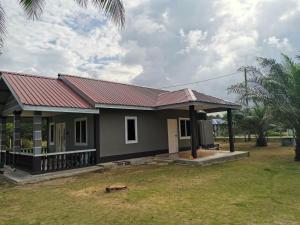 una pequeña casa con techo rojo en D Landai Budget Room Twin, en Pekan