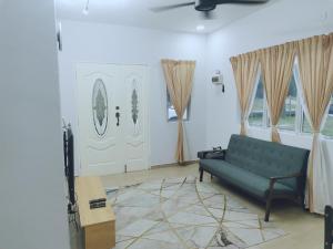 a living room with a couch and two windows at D Landai Budget Room Twin in Pekan