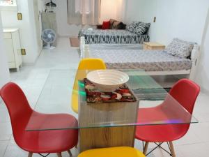 een eetkamer met een glazen tafel en 4 stoelen bij Apartamento A 43 Flat Centro in Mogi das Cruzes