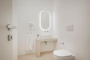 ein weißes Badezimmer mit Waschbecken und Toilette in der Unterkunft Marhaba in Torre Pali  + 30 Fotos