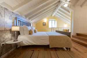 a bedroom with a large bed and a table at Chão do Rio - Turismo de Aldeia in Seia