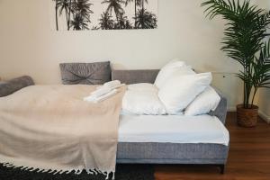un letto con cuscini bianchi sopra di Global Living - Design Apartment I Central I Beamer I Kitchen I Terrace I Berlin a Berlino