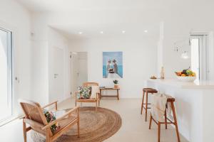 ein weißes Wohnzimmer mit Stühlen und einem Tisch in der Unterkunft Marhaba in Torre Pali 