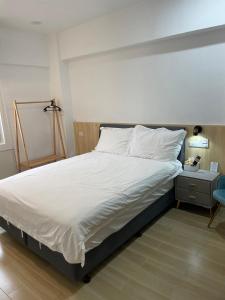 a bedroom with a large bed with white sheets at Happiness B&B in Linbian