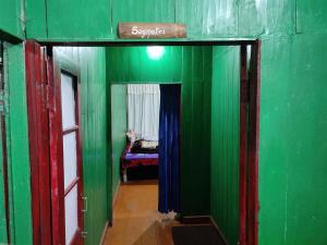 um quarto com paredes verdes e uma porta com uma cama em SHANTHI SAMAYA HOLIDAY HOMESTAY em Darjeeling