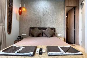 a bedroom with a bed with two remote controls at Cozzy Inn in Bhauli