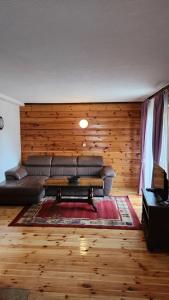 a living room with a couch and a coffee table at Olja Guest House in Žabljak