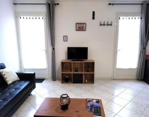 een woonkamer met een bank en een tv bij Les Gîtes d'Angres - Gîte n°3 in Angres