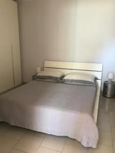 una camera da letto con un grande letto bianco con due cuscini di Scoglierauno a Bisceglie