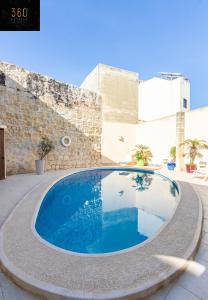a swimming pool in the middle of a courtyard at A stunning, townhouse with magnificent pool area by 360 Estates in Żebbuġ