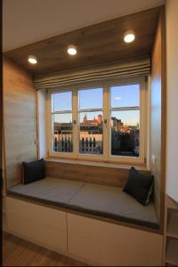 um assento na janela num quarto com vista para a cidade em Wawel View Apartment em Cracóvia