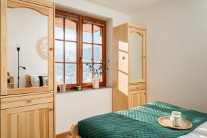 a bedroom with a green bed and a window at Highlander by LoftAffair in Kościelisko
