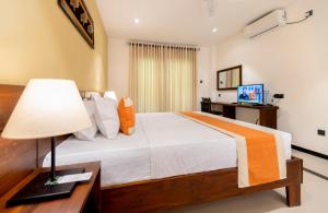 a bedroom with a bed and a desk with a lamp at Coastal Villa Mirissa in Mirissa