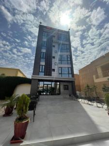 a tall building with a lot of windows and benches at Urban Hotel Nouakchott in Nouakchott