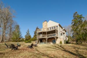 a large house sitting on top of a field at Misty Lake Hot Tub w Lake Access in Oak Ridge