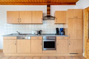 a kitchen with wooden cabinets and a stove top oven at Wanglerhof Familie Wangler in Schuttertal +26 photos