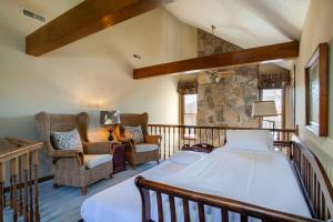 a bedroom with a bed and chairs in a room at Misty Lake Hot Tub w Lake Access in Oak Ridge