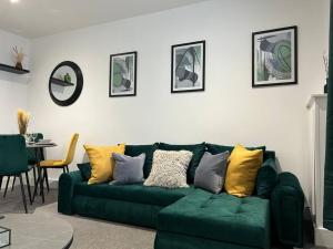un sofá verde en una sala de estar con mesa en City Centre 2 Bed - Long Stay Offer - Sleeps 6, en Strood