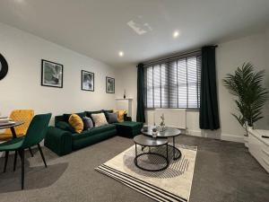 a living room with a green couch and a table at City Centre 2 Bed - Long Stay Offer - Sleeps 6 in Strood