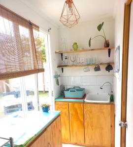 a kitchen with wooden cabinets and a sink at Loft a pasos de la playa in La Serena