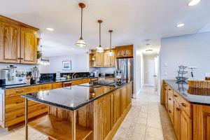 una cocina con armarios de madera y encimeras negras en Great Marsh House, en Essex