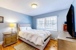 a bedroom with a bed and a tv and a window at Great Marsh House in Essex