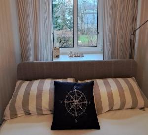 Un dormitorio con una ventana y una cama con almohada. en Liegeplatz 24, en Tönning