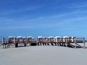 un muelle de madera con sillas en la playa en Liegeplatz 24, en Tönning 7 fotos más