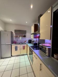 a large kitchen with white cabinets and appliances at Spacious Apartment with Balcony in Leicester