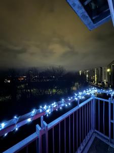 uma fila de luzes numa varanda à noite em Spacious Apartment with Balcony em Leicester