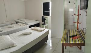 Zimmer mit 3 Betten und einer Bank in der Unterkunft indaiá Pousada - Posto da Mata-BA in Pasto da Mata