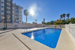 einen Pool mit einem Zaun und Palmen in der Unterkunft Villas Guzman - Apartamento Topacio IV in Calpe