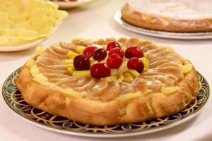 a pie with fruit on a plate on a table at Hotel Portonuovo in Vieste