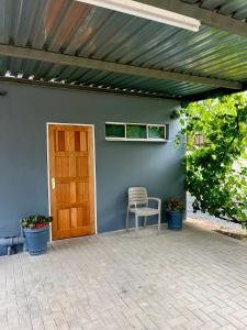 a patio with a wooden door and a chair in front of a house at Wamelia Guesthouse in Bloemfontein