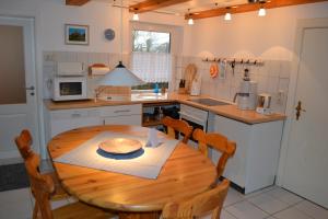 a kitchen with a wooden table and a table and chairs at EG Inge in Katharinenheerd
