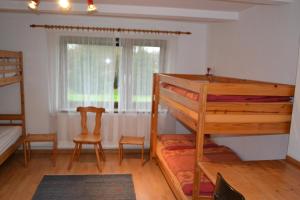 a bedroom with a bunk bed and a chair and a window at EG Inge in Katharinenheerd