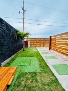 un jardin avec un banc et une clôture dans l'établissement Casa Caballito de mar-Seahorse House, à Bahía de Caráquez