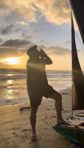 a man standing on the beach looking at the ocean at POUSADA CHALÉ PARAÍSO - Icapui in Icapuí